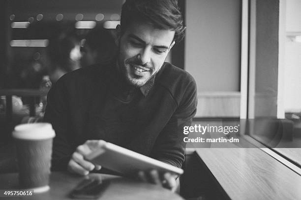 man in a cafe using tablet pc - black and white cafe stock pictures, royalty-free photos & images