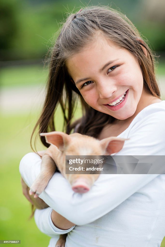 Chica sosteniendo un cerdo