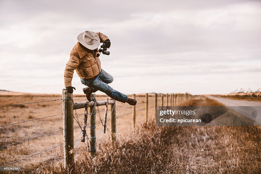 Rancher jumps over barbed wire fence to get to road