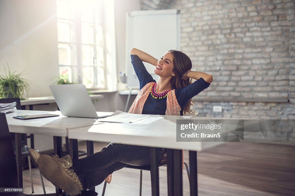 Junge entspannte Geschäftsfrau nimmt eine Pause im Büro.