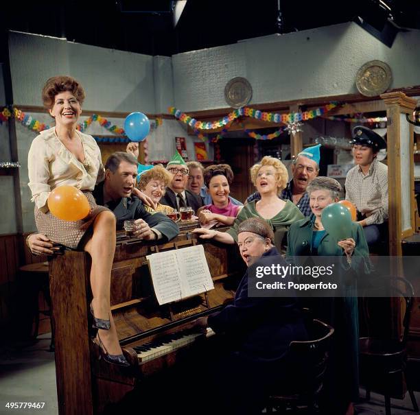 View of the cast of the television soap opera 'Coronation Street' in a Christmas scene around an upright piano in 1968. Actors in the scene include...