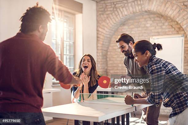 playful business team playing table tennis at casual office. - table tennis stock pictures, royalty-free photos & images