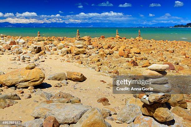 small rock cairns by beach in abel tasman - abel tasman national park stock pictures, royalty-free photos & images