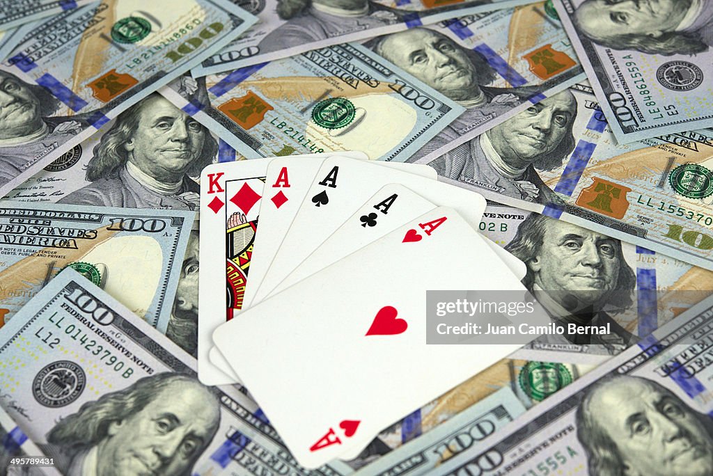 Poker of aces over new one hundred dollar bills