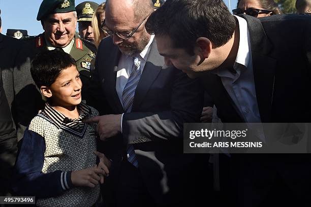 Greek Prime Minister Alexis Tsipras and European parliament President Martin Schulz speaks to a young migrant as they visit the Moria Hot Spot in...