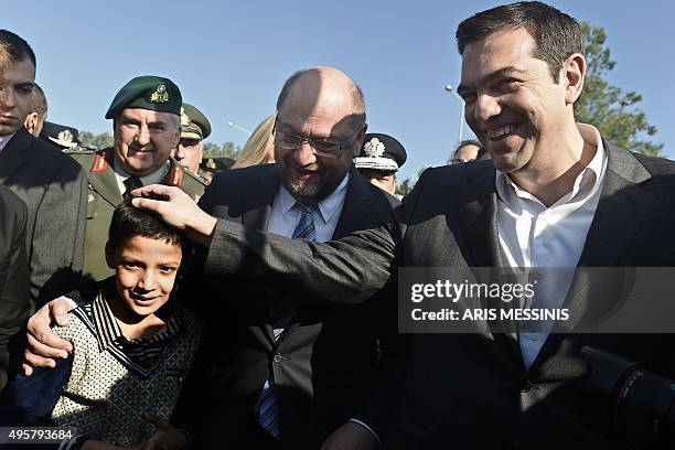 Greek Prime Minister Alexis Tsipras and European parliament President Martin Schulz speaks with a young migrant as they visit the Moria Hot Spot in...