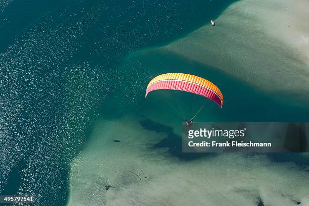 paraglider over the maggia river delta with naturally formed water and rocks terrain, locarno, kanton tessin, switzerland - kanton tessin stock pictures, royalty-free photos & images