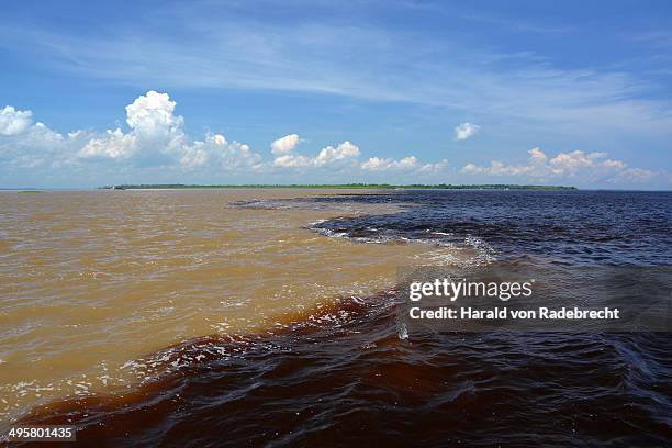 encontro das aguas, the meeting of waters, the confluence of the white water river rio solimoes and black water river rio negro, further down river is called amazon, manaus, amazonas state, brazil - encontro stock pictures, royalty-free photos & images