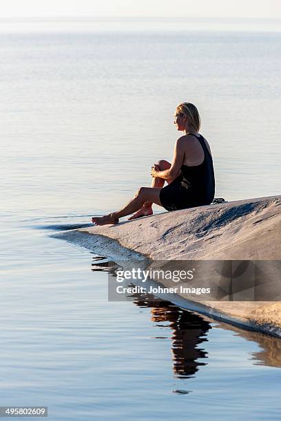 woman sitting at sea, sweden - archipelago stockfoto's en -beelden