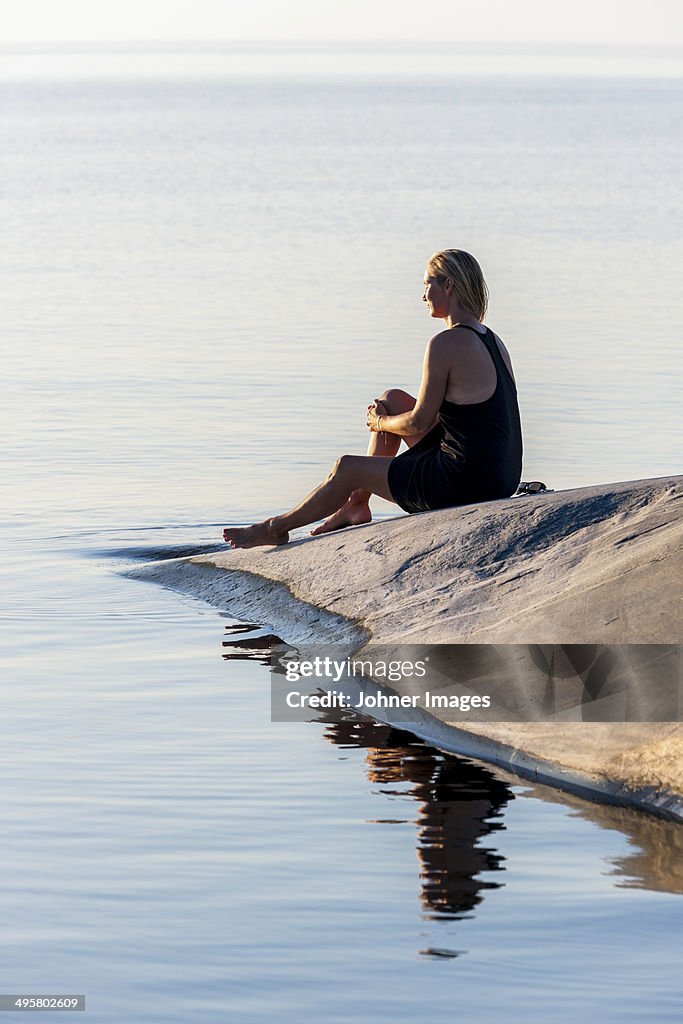 Woman sitting at sea, Sweden