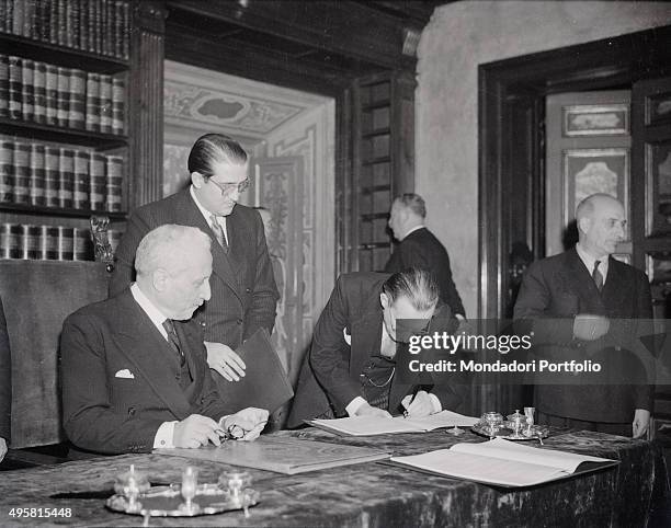 The President of the Council of Ministers of the Italian Republic Alcide De Gasperi signing the Constitution of the Italian Republic under the eyes...