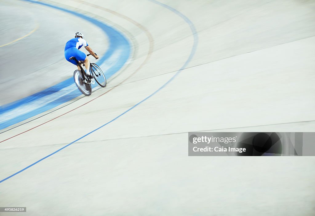 Track cyclist riding around velodrome