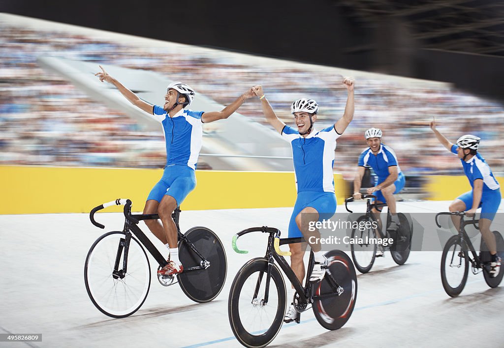 Track cycling team celebrating in velodrome