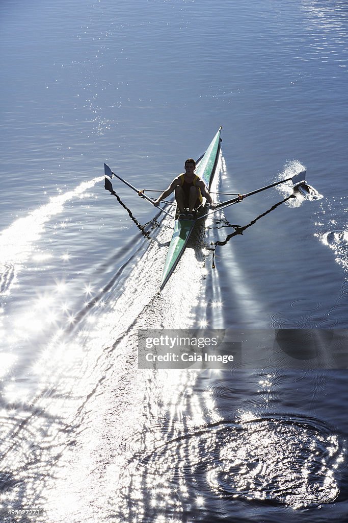 Man rowing scull on lake