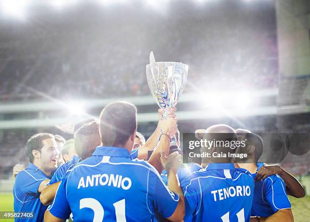 soccer team celebrating with trophy on field - football team trophy stock pictures, royalty-free photos & images