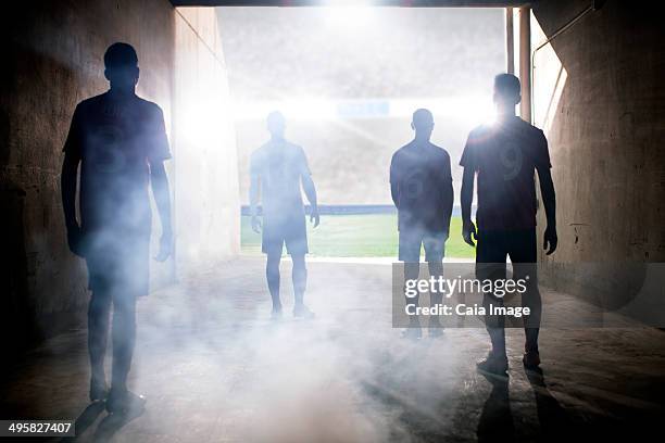 silhouette of soccer teams facing field - afternoon soccer stock-fotos und bilder