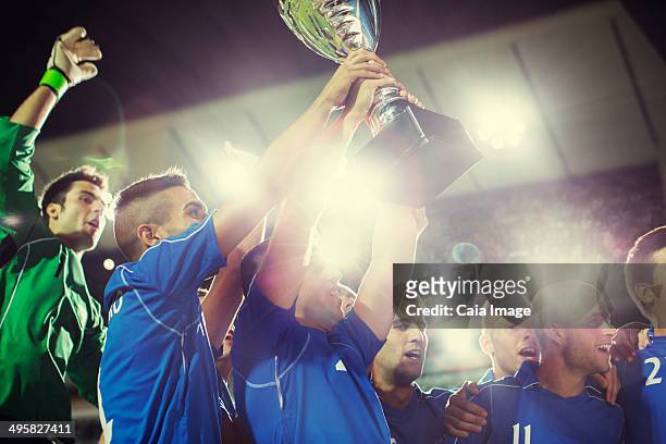 soccer team celebrating with trophy on field - soccer team stock pictures, royalty-free photos & images