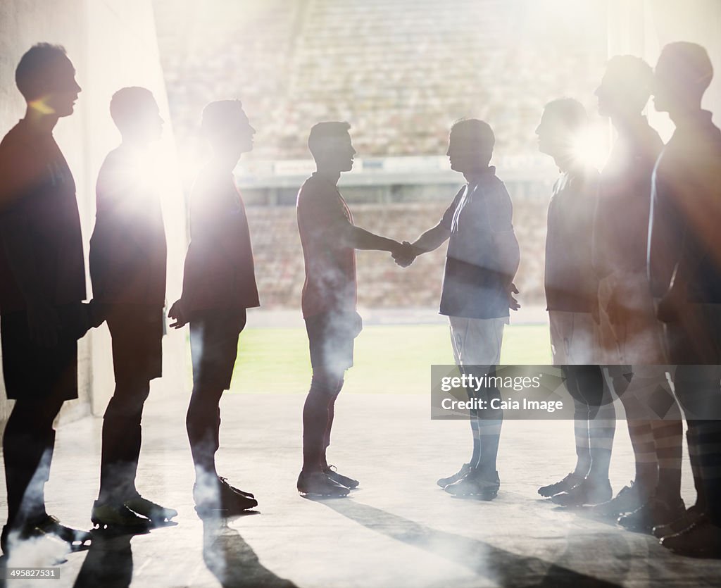 Silhouette of soccer teams shaking hands