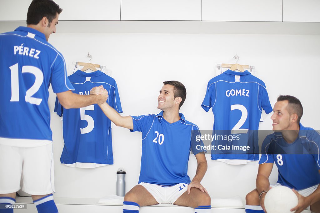 Soccer players shaking hands in locker room