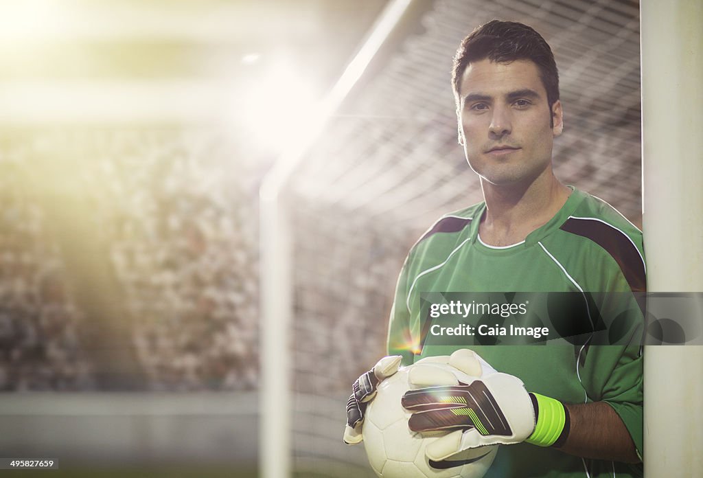 Goalie holding ball in soccer net