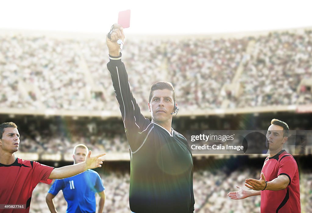 Referee flashing red card in soccer game