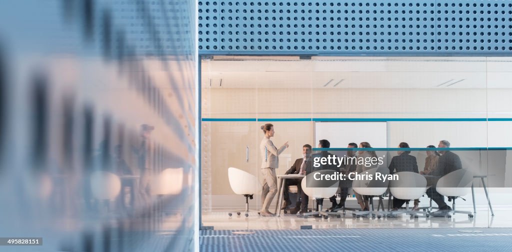 Businesswoman leading meeting in modern conference room