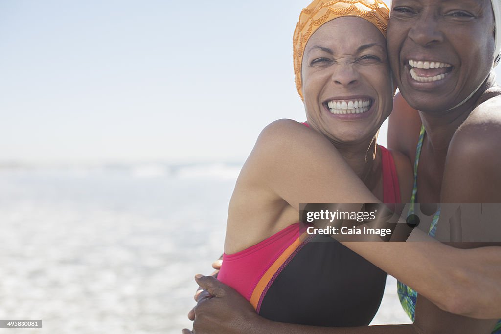 Enthusiastic women hugging on beach