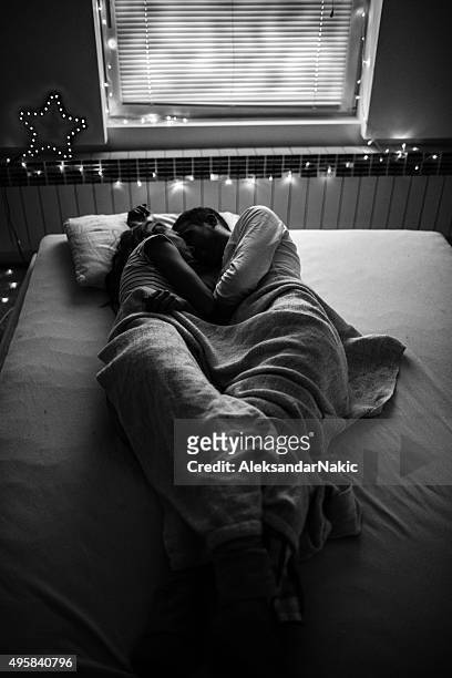 nighttime romance - man and woman kissing in bed stock pictures, royalty-free photos & images
