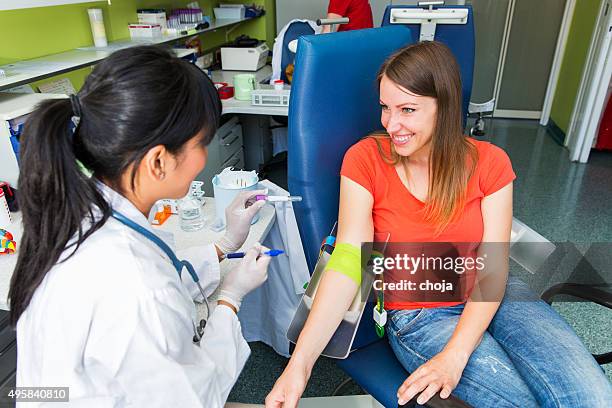 drawing blood...young doctor prepairing for blood capture - iv going into an arm stock pictures, royalty-free photos & images