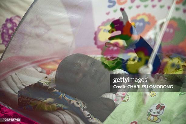 One-year-old Nyalou Thong, survivor of a cargo plane crash, rests on a bed at a hospital in Juba on November 5, 2015. A Russian-built Antonov An-12...