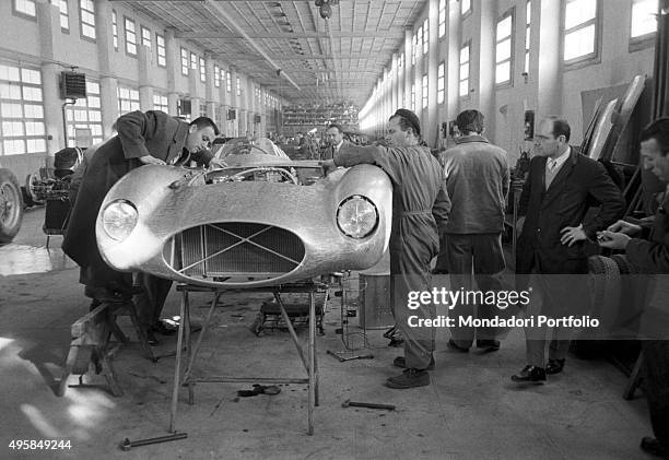 The billionaire entrepreneur Tony Parravano observing a Ferrari race car under construction. Modena, 1950s