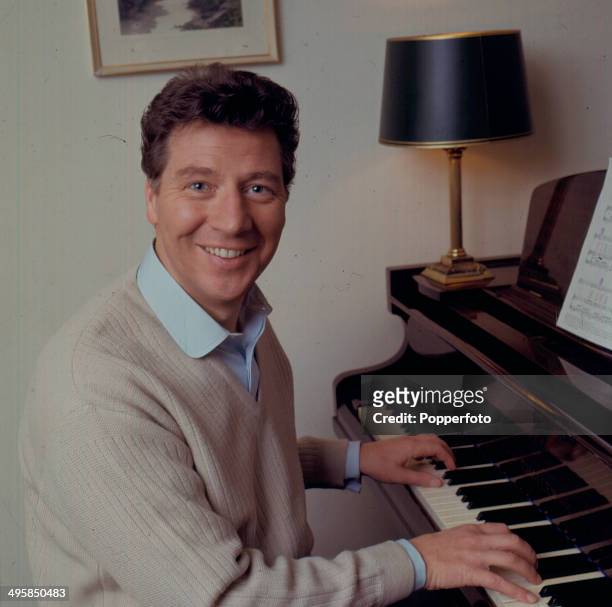 English comedian and singer Max Bygraves posed sitting at a grand piano in 1967.