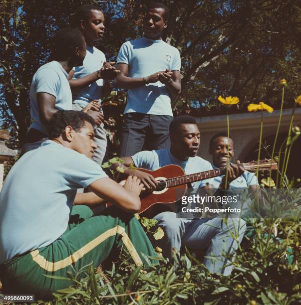 Brazilian footballer Pele plays an acoustic guitar surrounded by Brazil teammates at a training session in Paineiras, Brazil before the team leaves...