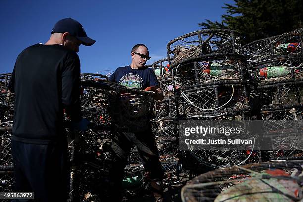 Chris Swim and Nick White stack crab traps in the parking lot of the Pillar Point Harbor on November 5, 2015 in Half Moon Bay, California. The...