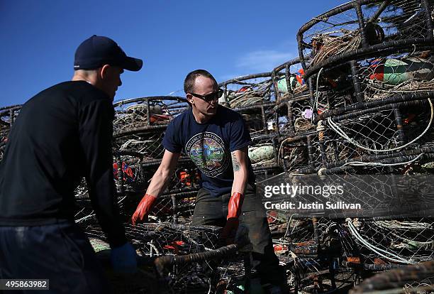 Chris Swim and Nick White stack crab traps in the parking lot of the Pillar Point Harbor on November 5, 2015 in Half Moon Bay, California. The...