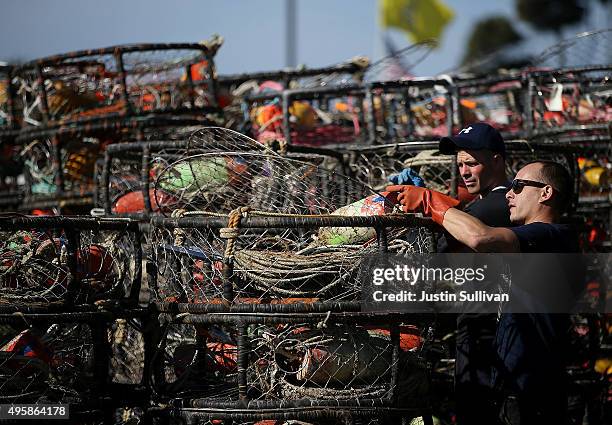 Chris Swim and Nick White repair crab traps in the parking lot of the Pillar Point Harbor on November 5, 2015 in Half Moon Bay, California. The...