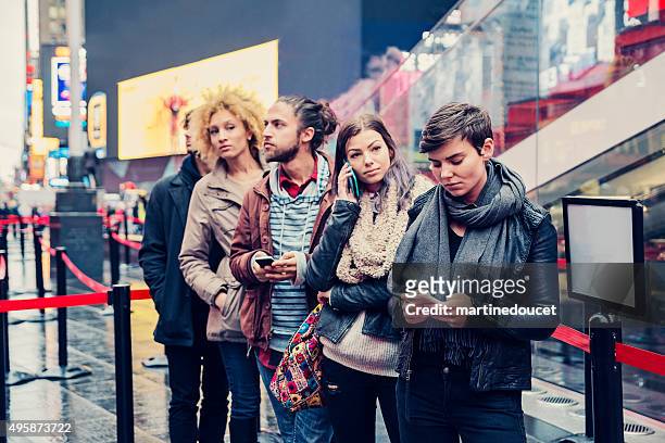 giovani in attesa in linea per acquistare biglietti aerei per new york. - in fila foto e immagini stock