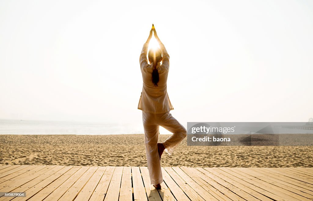 Femme dans la pose de yoga sur la plage
