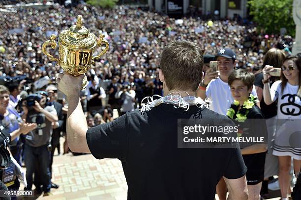 New Zealand's All Blacks rugby team captain Richie McCaws holds the Webb Ellis Cup during a parade through the central business district of...