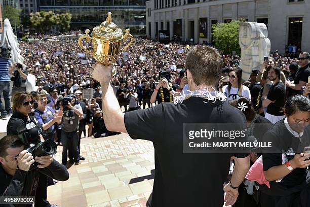 New Zealand's All Blacks rugby team captain Richie McCaws holds the Webb Ellis Cup during a parade through the central business district of...