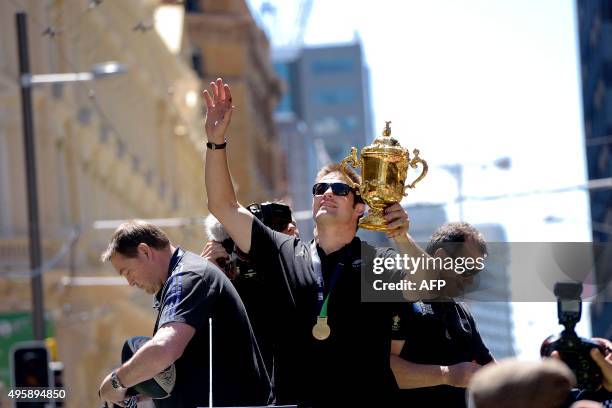 New Zealand's All Blacks rugby team Richie McCaw holds the holds the Webb Ellis Cup during a parade by the team through the central business district...