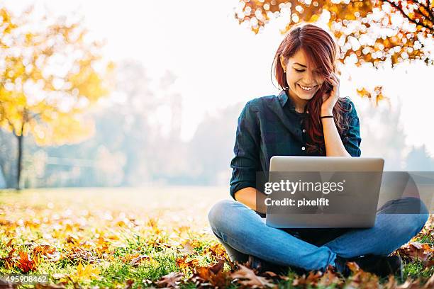 ragazza con computer durante l'autunno - girl looking at computer foto e immagini stock