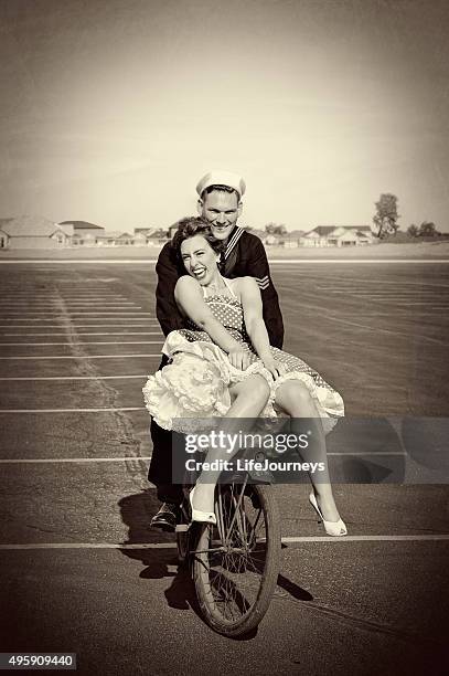 wwii navy mann und seine hübsche frau auf einem fahrrad - petticoat stock-fotos und bilder