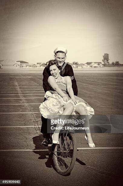 wwii navy man and his pretty woman riding a bike - underklänning bildbanksfoton och bilder