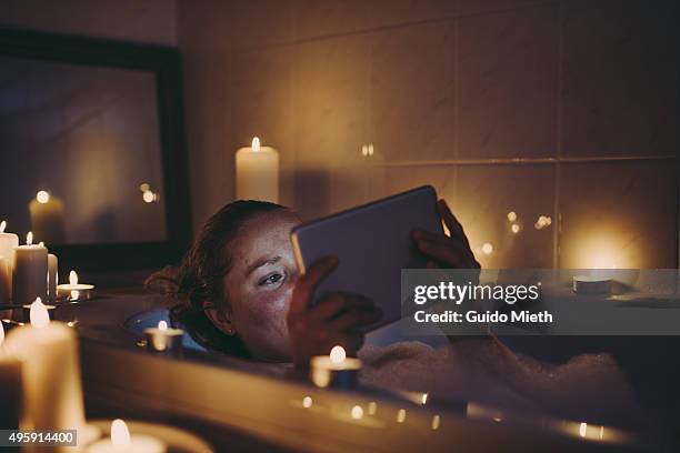 woman using tablet pc in bathtub. - beautiful woman bath stockfoto's en -beelden