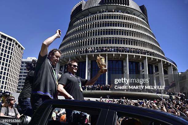 New Zealand's All Blacks rugby team captain Richie McCaws holds the Webb Ellis Cup with team coach Steve Hansen as they drive past parliament...