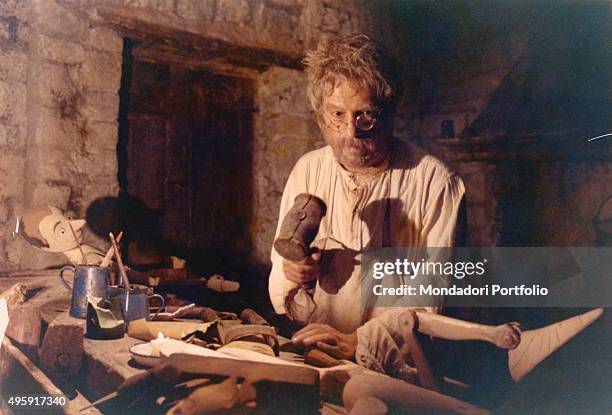 Italian actor Nino Manfredi as Geppetto making Pinocchio on a woodworker table in the TV mini-series The Adventures of Pinocchio. 1972