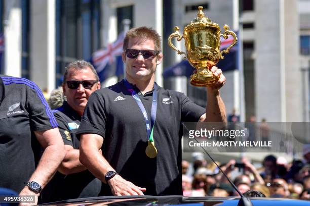 New Zealand's All Blacks rugby team Richie McCaw holds the Webb Ellis Cup during a parade by the team through the central business district of...