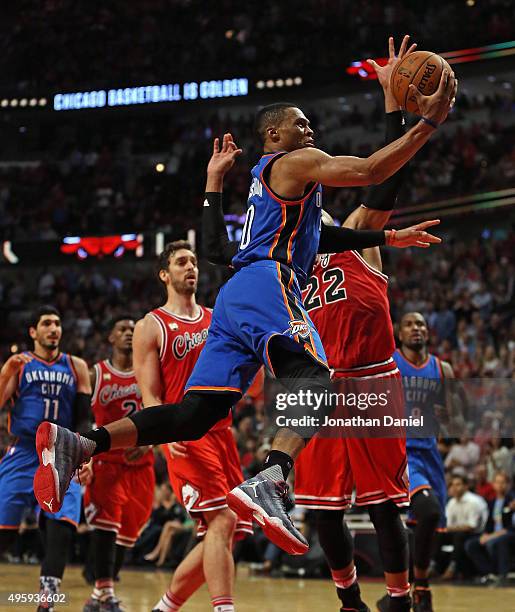 Russell Westbrook of the Oklahoma City Thunder drives to the basket past Pau Gasol and Taj Gibson of the Chicago Bulls at the United Center on...