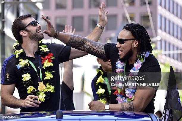 New Zealand's All Blacks rugby team players Ma'a Nonu and Conrad Smith wave to fans during a parade by the team through the central business district...